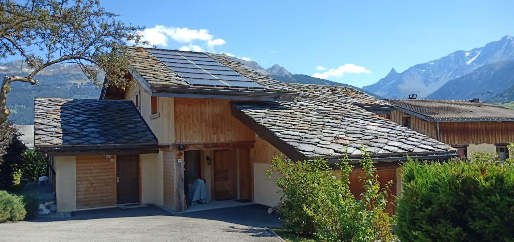 a house with solar panels on the roof at Maison cœur tarentaise in Les Chapelles