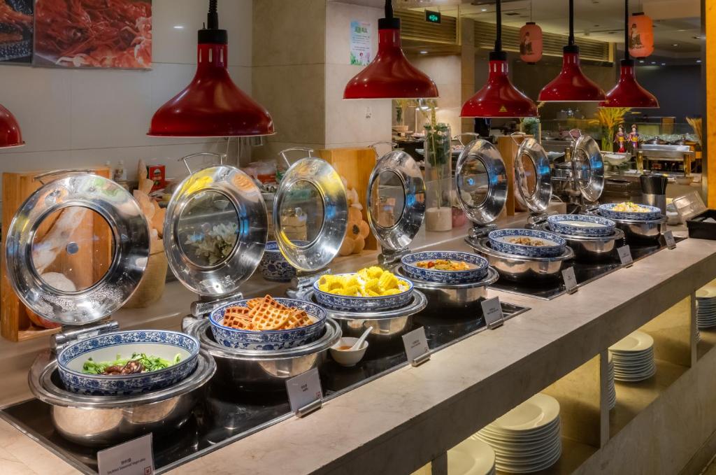 a buffet line with bowls and plates of food at Belgravia Serviced Residence Wuxi in Wuxi