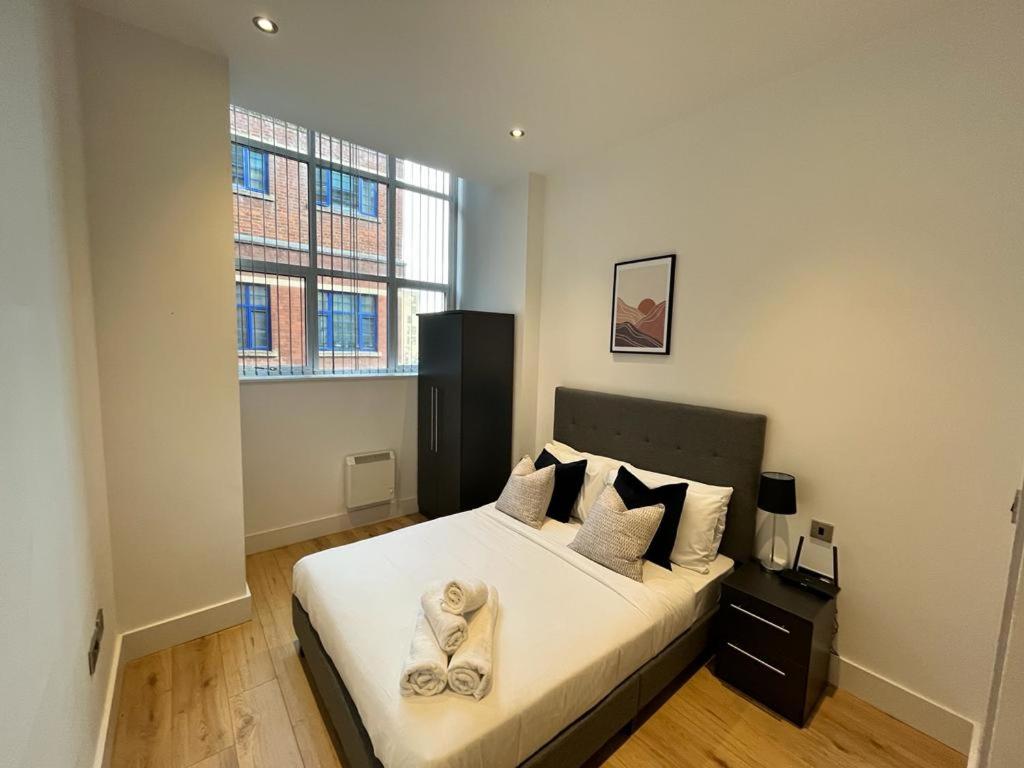 a bedroom with a bed with two towels on it at Stunning mill apartment near to city centre and Etihad stadium! in Manchester