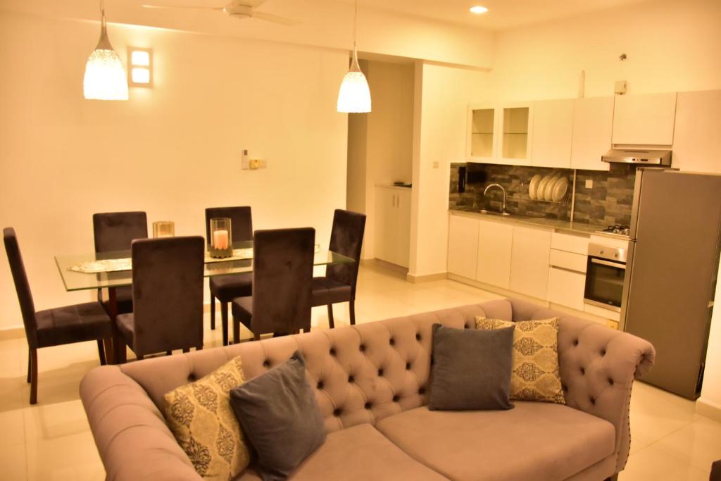 Nawala的住宿－BNB RESIDENCIES NAWALA，客厅以及带沙发和桌子的厨房。