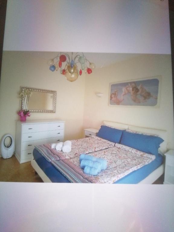 1 dormitorio con 1 cama con sábanas azules y almohadas azules en Casa Silvio, en Torri del Benaco