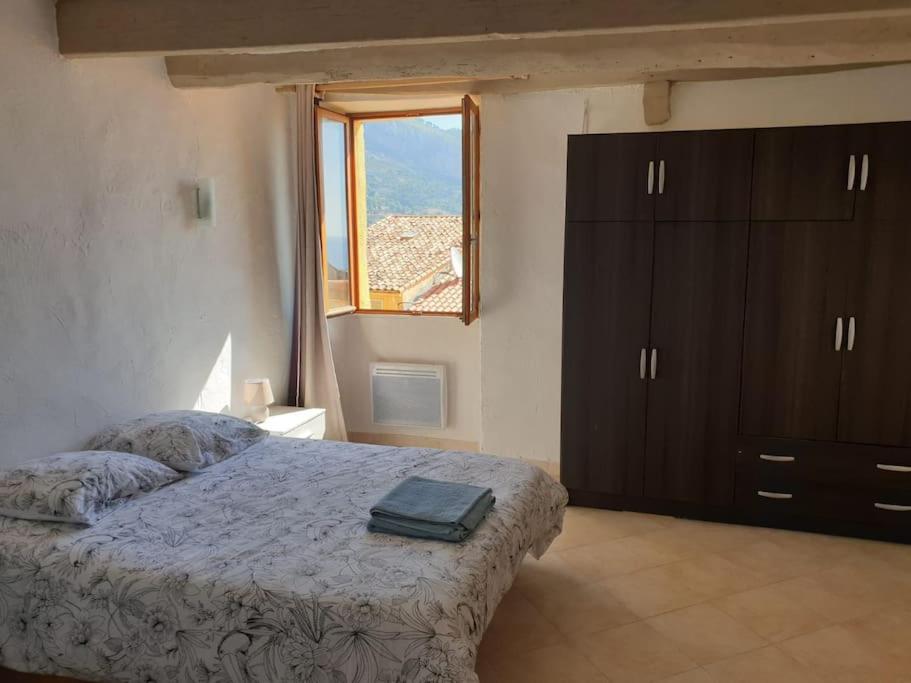 sypialnia z łóżkiem z komodą i oknem w obiekcie Duplex vue mer 50m de la plage des Sablettes w Mentonie