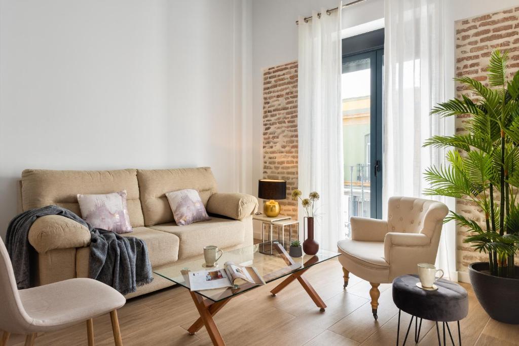 salon z kanapą i 2 krzesłami w obiekcie One&lux Puerta Osario w Sewilli