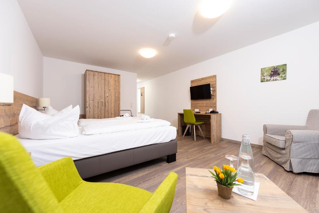 um quarto de hotel com uma cama, uma mesa e cadeiras em Hotel garni Milseburg em Hilders