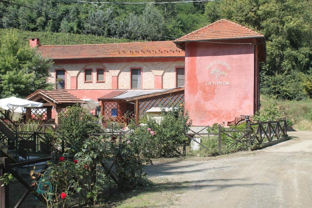 a building with a fence in front of a garden at Agriturismo La.Ti.Mi.Da. in Cassine