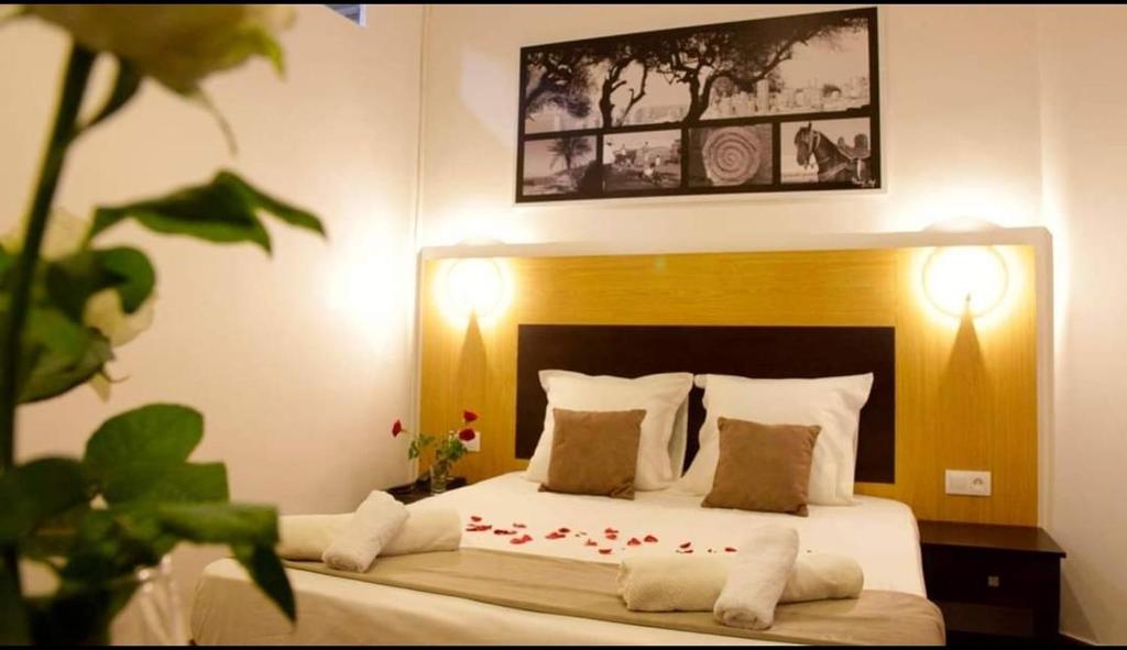 1 dormitorio con 1 cama con sábanas y almohadas blancas en Hotel de la Poste en Kasbah