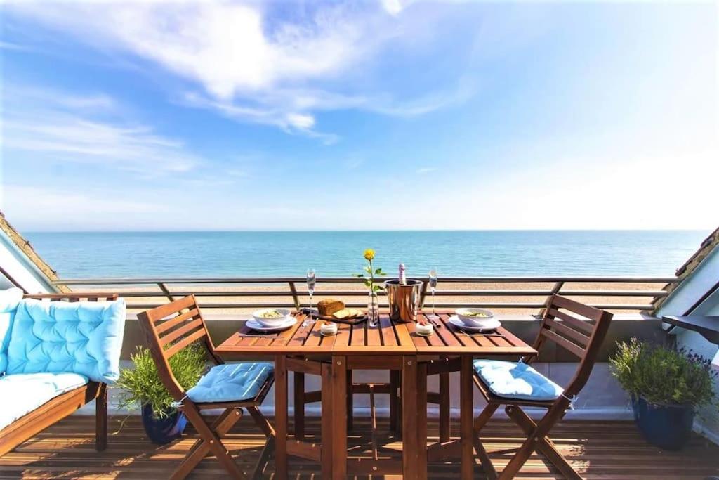 uma mesa e cadeiras numa varanda com o oceano em The luxury Beach property - Oceanbreeze em Sandgate