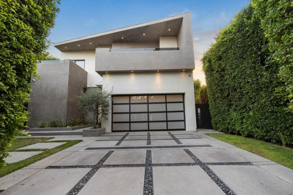 ein Haus mit Garagentor und Hecke in der Unterkunft Orlando Estate in Los Angeles