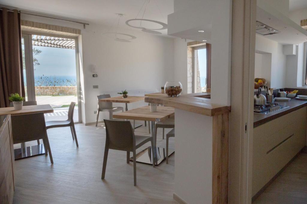 a kitchen and dining room with a table and chairs at Daedalium in Marina di Palma