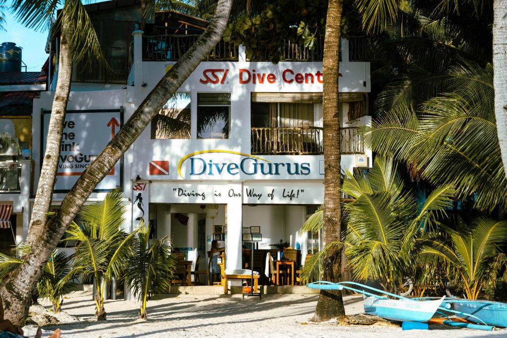 a building on the beach with palm trees at DiveGurus Boracay Beach Resort in Boracay