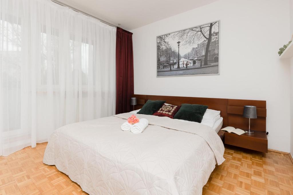 a bedroom with a large white bed with areath on it at Warsaw Magellana Apartment by Renters in Warsaw