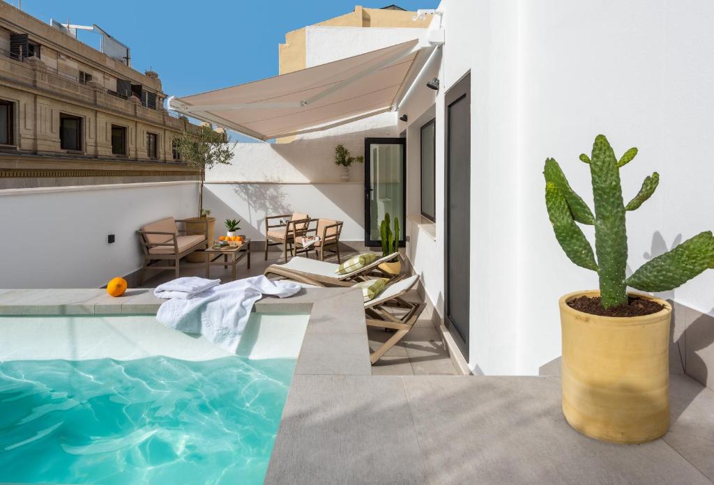 een huis met een zwembad en een cactus bij Magno Apartments Cabo Noval Luxury House in Sevilla