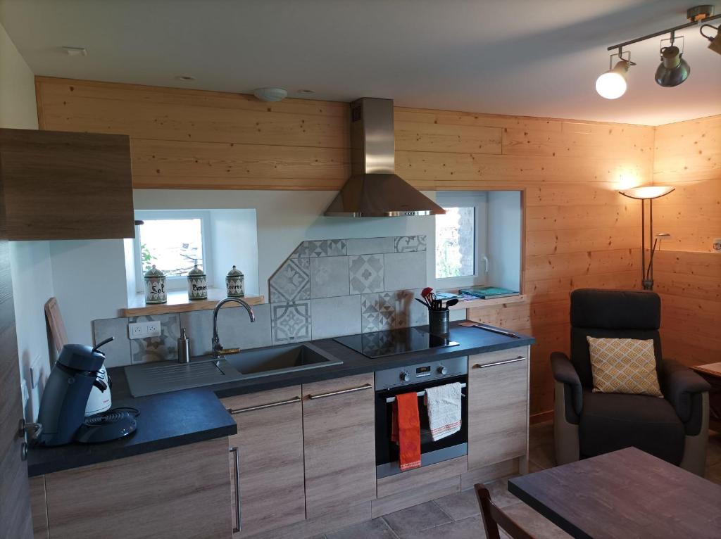 a kitchen with a sink and a stove at Gîte Massatho tout confort avec jardin in Fay-en-Montagne