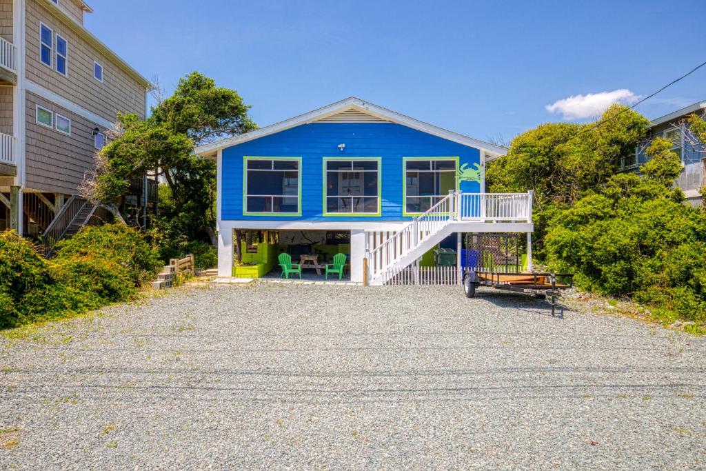 een blauw huis met een witte veranda en een oprit bij Blue Crab in Surf City