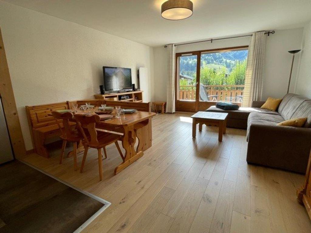 un salon avec une table et un canapé dans l'établissement Spacieux 4 pièces avec parking et vue imprenable à Praz-sur-Arly - FR-1-603-40, à Praz-sur-Arly