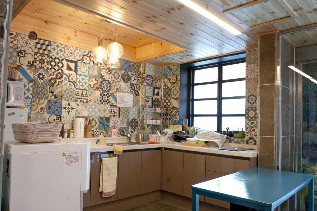 a kitchen with a refrigerator and a table in it at Twin Rabbit Guesthouse in Seoul