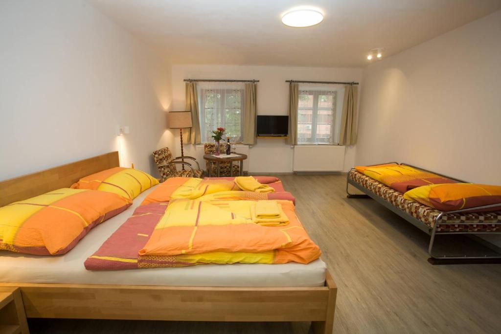 1 dormitorio con 2 camas con sábanas de color naranja y amarillo en apartmany Zak, en Frymburk