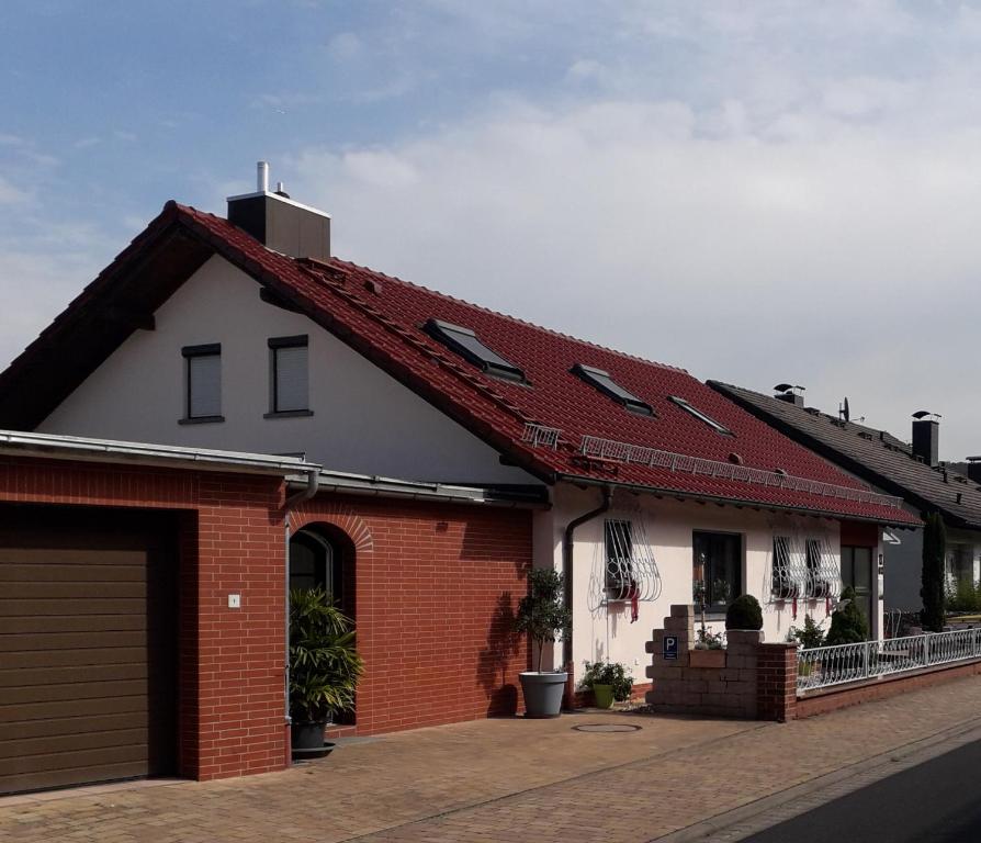 a red and white house with a garage at Gästehaus Natterer - FeWo 1 in Momlingen