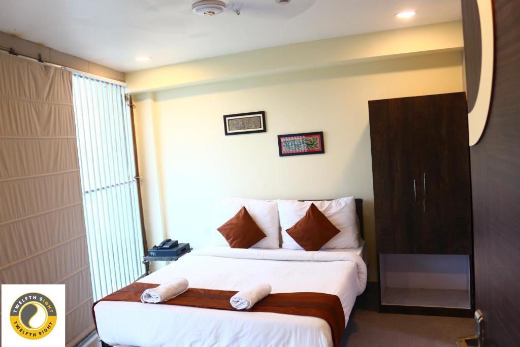 a hotel room with a bed with a large window at Twelfth 9ight in Nager Bazaar