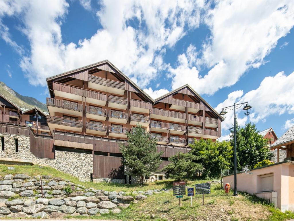 a large wooden building with balconies on a mountain at Vacancéole - Le Dôme des Rousses in Vaujany