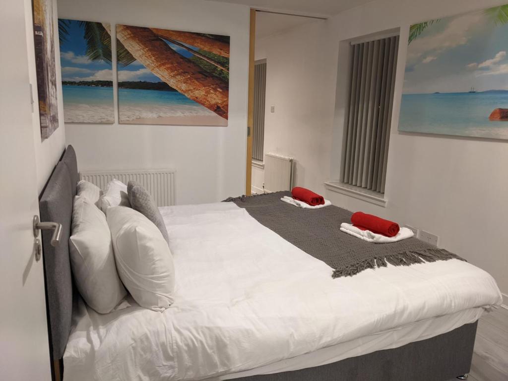 a bedroom with a large white bed with pillows at Glasgow City Centre Waterfront Apartment in Glasgow