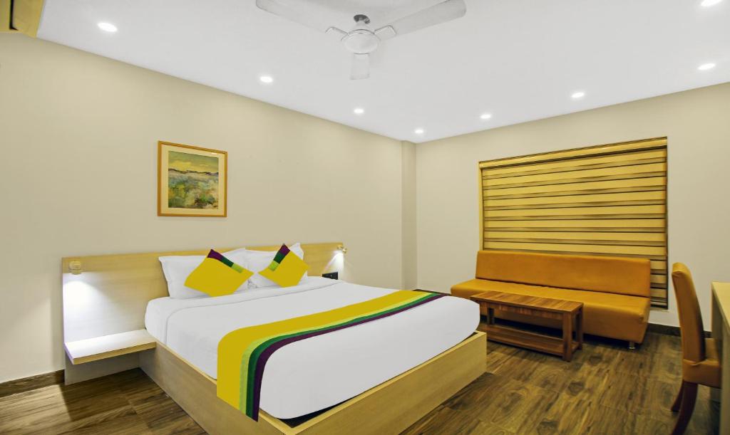 a bedroom with a bed and a bench in it at Itsy By Treebo - Transit Express in Kolkata