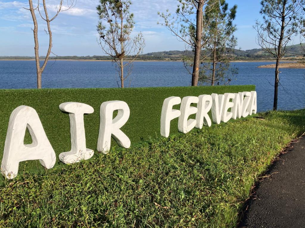 a sign in the grass next to a body of water at AIR FERVENZA in Dumbría
