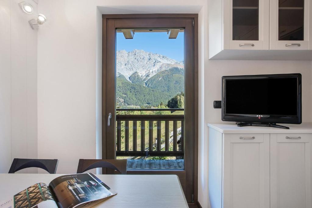 a room with a television and a view of a mountain at Appartamento Silvia in Valdisotto