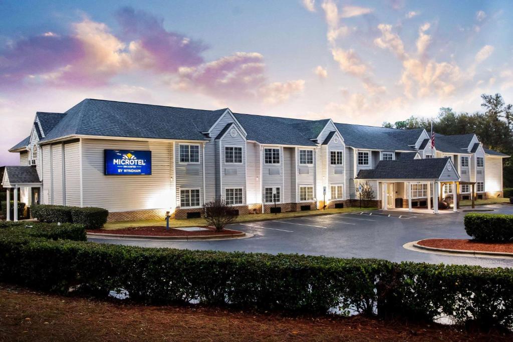 a large white building with a parking lot at Microtel Inn & Suites by Wyndham Southern Pines Pinehurst in Southern Pines