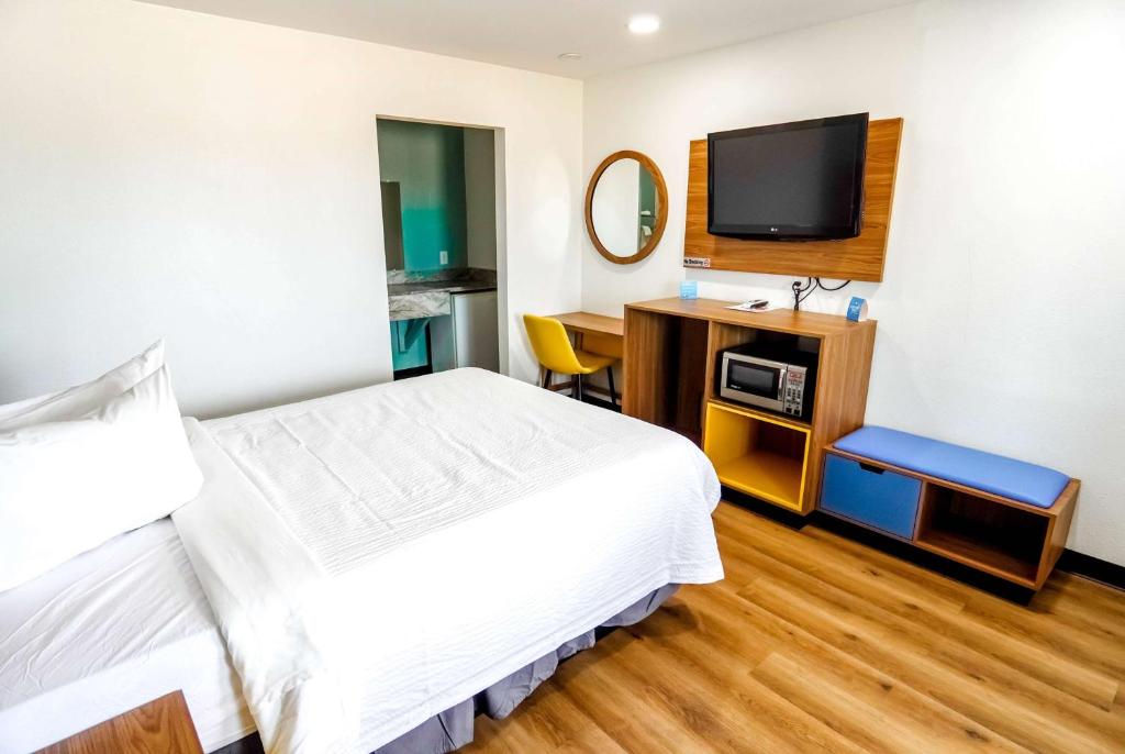 Cette chambre comprend un lit et une télévision à écran plat. dans l'établissement Days Inn by Wyndham Victorville, à Victorville