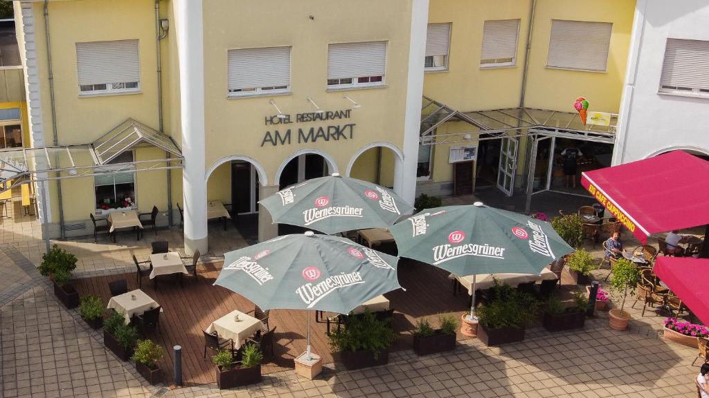 eine Gruppe von Sonnenschirmen vor einem Gebäude in der Unterkunft Warias Hotel & Restaurant in Braunsbedra