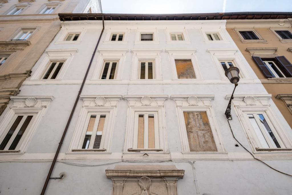 ein weißes Gebäude mit vielen Fenstern und einem Straßenlicht in der Unterkunft 59 Steps Trevi in Rom