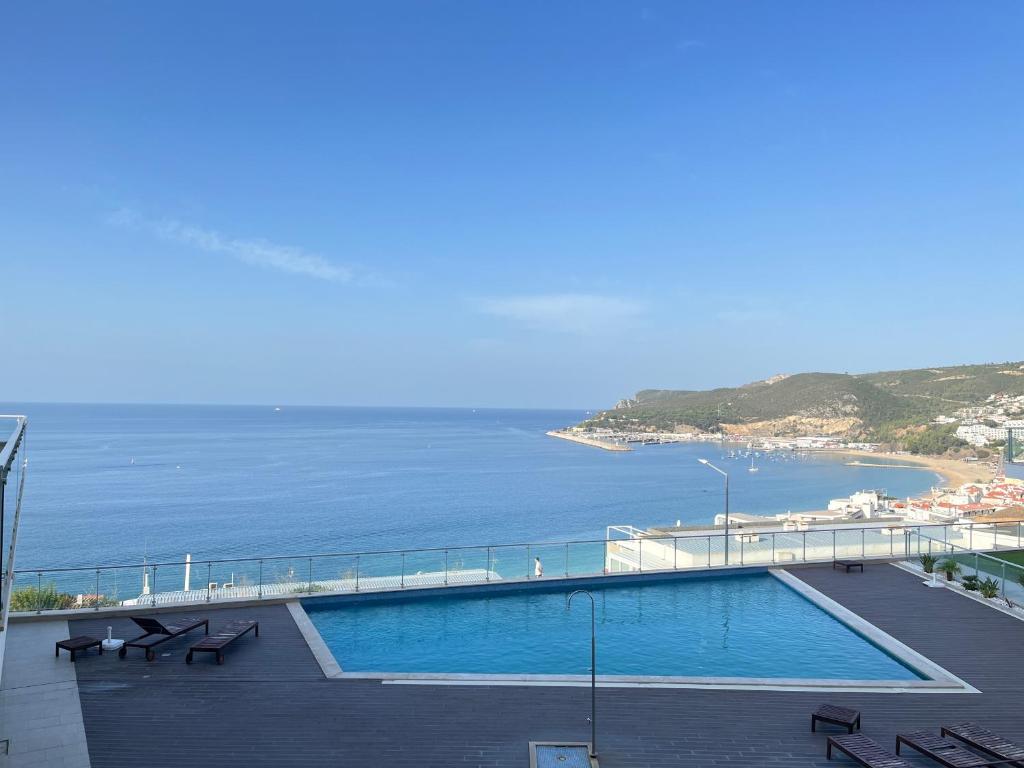 a swimming pool with a view of the ocean at Cliffs Apartment - Astonishing view over Sesimbra bay by Trip2Portugal in Sesimbra
