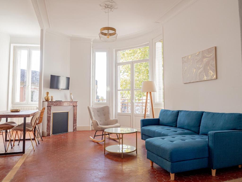 a living room with a blue couch and a table at Le CosyChic - Appartement élégant en centre ville in Orange