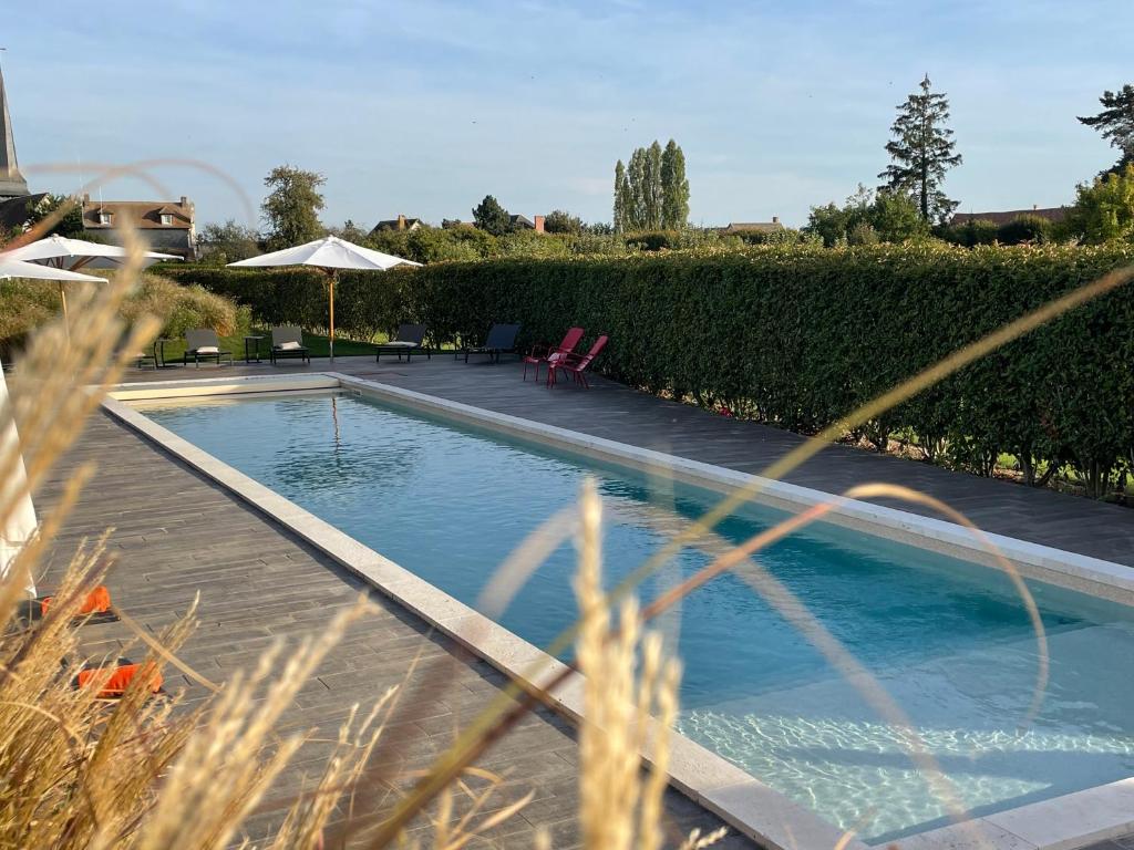 - une piscine au milieu d'une cour dans l'établissement Manoir de Surville, à Surville