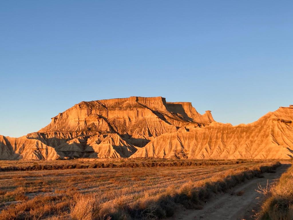 un camino de tierra frente a una montaña en Hostel Bardenas, en Cabanillas