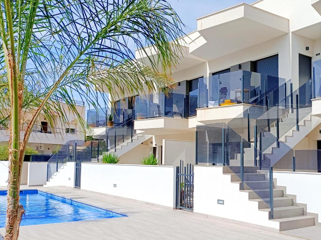 una casa con una piscina y una palmera en Elisa Beach Apartment - 8209, en Santiago de la Ribera