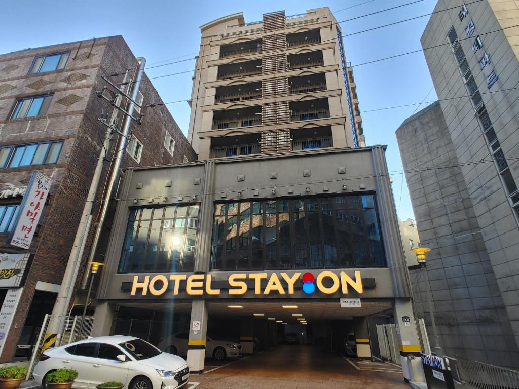 un soggiorno in hotel su un cartello di fronte agli edifici di Hotel STAYON a Geoje