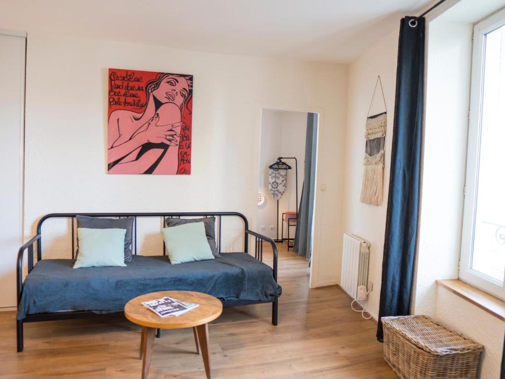 een slaapkamer met een bed en een tafel in een kamer bij La Grande Maison Clermont - Appartements centre ville in Clermont-Ferrand