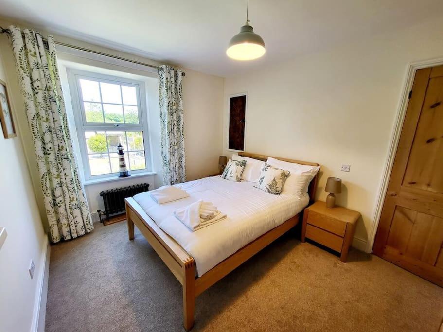 a bedroom with a large bed and a window at 8 Duke Street - Launceston Cornwall in Launceston