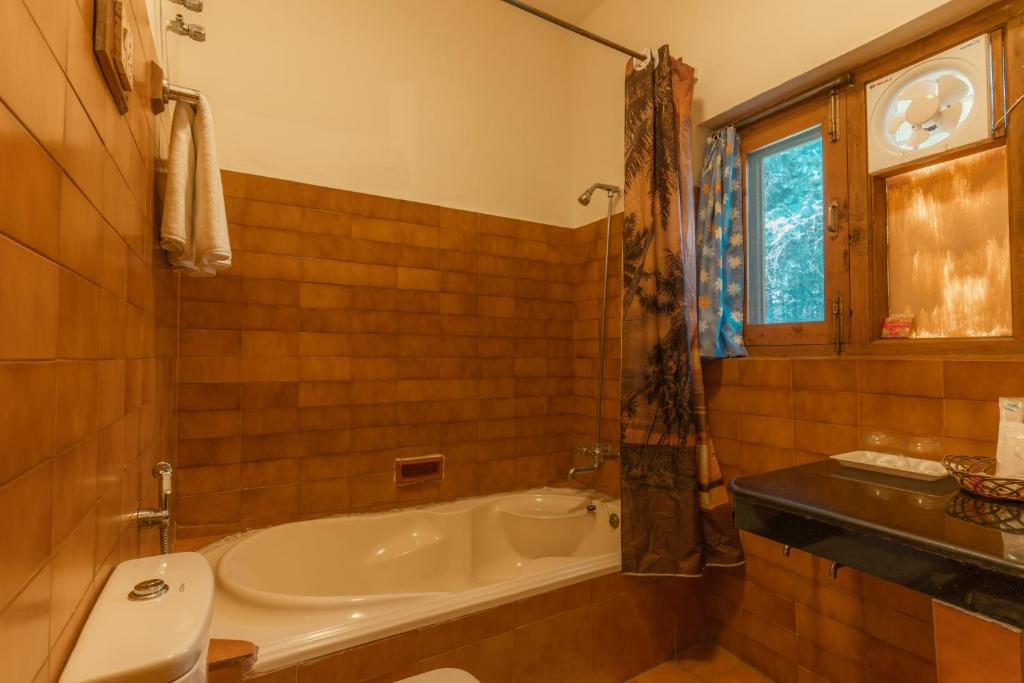 uma casa de banho com uma banheira e um lavatório em Hotel Negi's Mayflower A heritage Since 1965 em Manali
