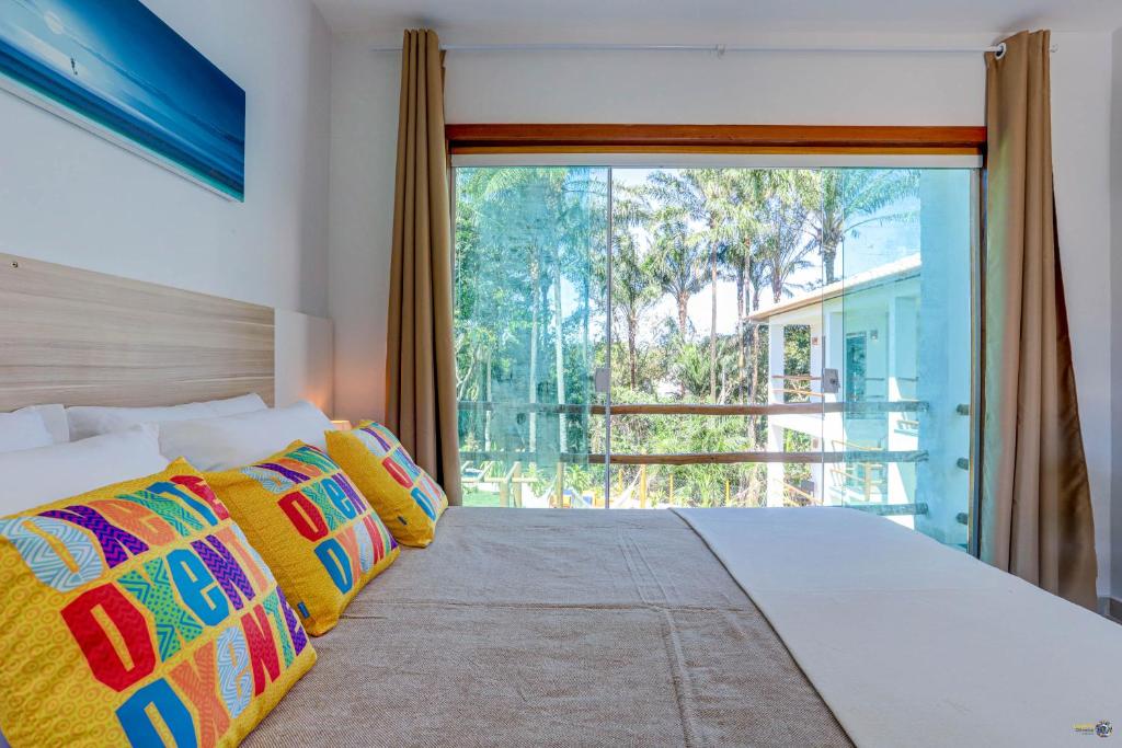 sypialnia z łóżkiem i dużym oknem w obiekcie Pousada Céu & Mar de Taipu w mieście Barra Grande