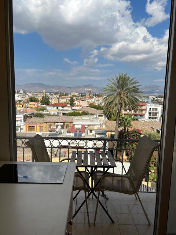balcón con mesa, sillas y vistas en Nicosia City Centre Sky Views Apartment, en Nicosia