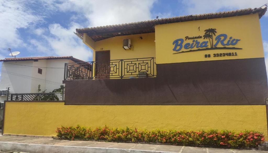 een geel gebouw met een bord aan de zijkant bij Pousada Beira Rio Parnaíba in Parnaíba