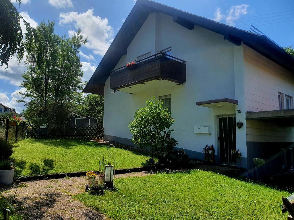 Cette maison blanche dispose d'un balcon et d'une cour. dans l'établissement Albblick, à Bad Herrenalb