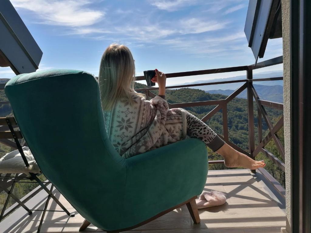 Una mujer sentada en una silla toma una foto de la vista en Magic View E16 Kopaonik, en Kopaonik
