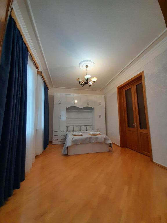 a bedroom with a bed and a chandelier on the ceiling at Belas House With Terrace in Kutaisi