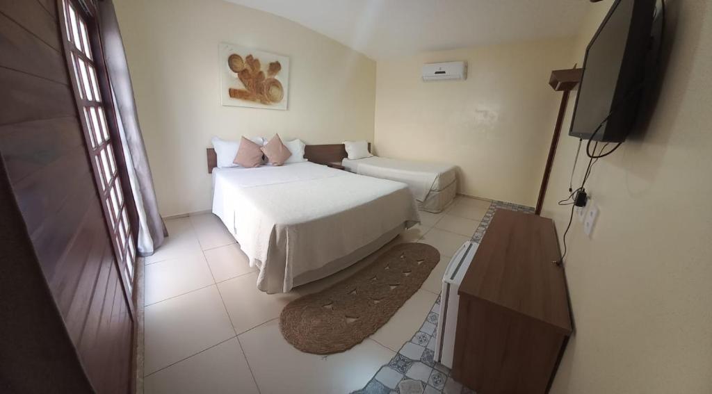 a bedroom with a bed and a flat screen tv at Pousada Beira Rio Parnaíba in Parnaíba