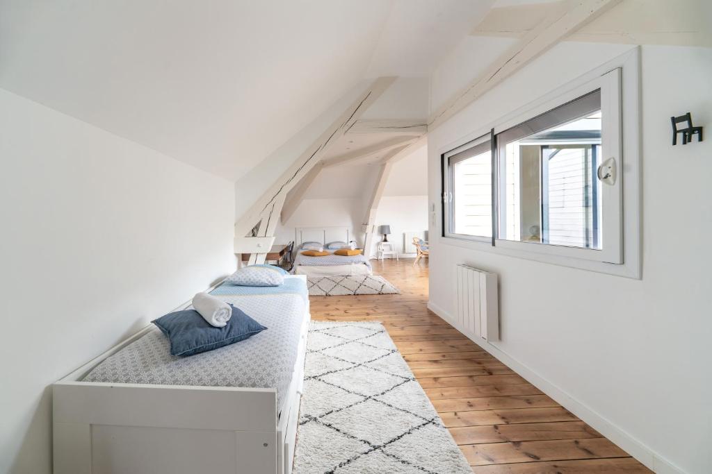 een witte kamer met een bed en een raam bij Grande Maison Vichy - Maison ou Appartements en Centre ville in Vichy