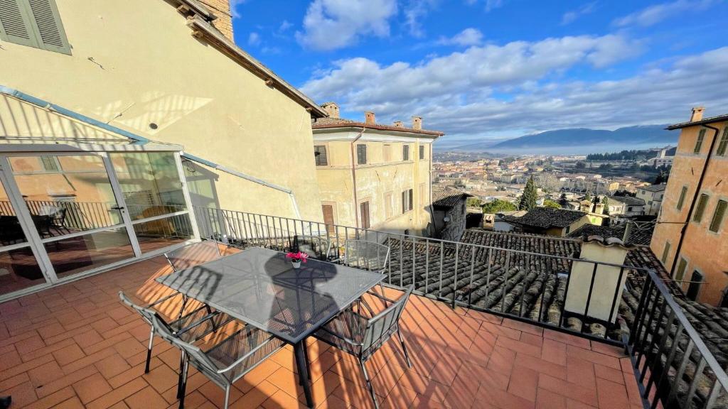 eine Terrasse mit einem Tisch und Stühlen auf dem Balkon in der Unterkunft Central Huge terrazza Duomo With Spectacular Views - sleeps 6 in Spoleto